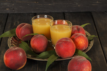 Peach fresh juice with fresh peaches on a dark background. Top view, copy space. Healthy eating. Fresh juice with peach.
