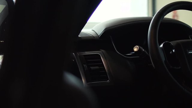 Dark luxury car Interior - steering wheel dashboard. Stock. Presentation of the car through the driver's door