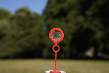 Red bubble stick with a big and a small hole to blow covered with foam