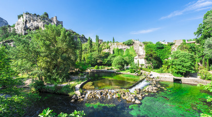 The river Sorgue in Fontaine de Vaucluse in the background the castle ruins from Philp Cabassole. Vaucluse, Provence, France, Europe - obrazy, fototapety, plakaty