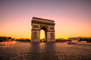 Arch of triumph at twilight. Arc de Triomphe at end of Champs Elysees in Place Charles de Gaulle with cars and trails of lights. Popular landmark and tourist attraction in Paris capital of France. - obrazy, fototapety, plakaty