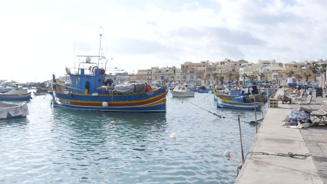 Marsaxlokk, Malta - beautiful fishing village architecture with colored boatsat at anchor in a bay