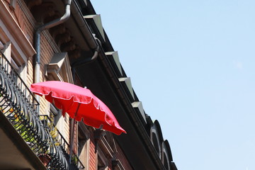 red  sun blind on a balcony of a city house