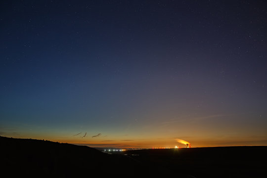 Stars of outer space in the night sky over the river valley. Landscape in the twilight on long exposure.