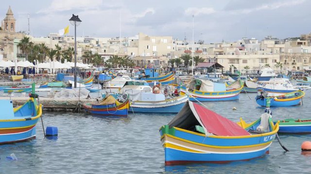 Marsaxlokk, Malta - beautiful fishing village architecture with colored boatsat at anchor in a bay