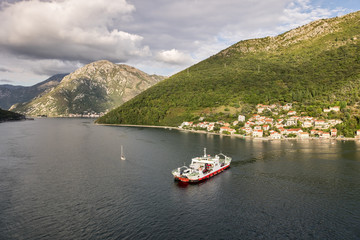Fototapeta na wymiar Aerial view of ferry boat in open waters in Kotor Bay, Montenegro