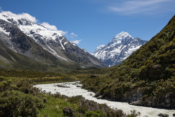 Fototapeta na wymiar Fast flowing river with Mount Cook in the distance at Aoraki Mount Cook national park, New Zealand