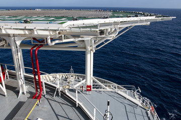 Helideck on the helicopter landing ship in the blue sea 