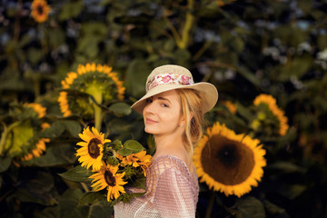 Beautiful woman in a rural field scene outdoors, with sunflowers and sunhat, lust for life, summerly, autumn mood 