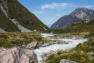 Fototapeta na wymiar Red rock formations and river at Aoraki Mount Cook national park, south island, New Zealand.