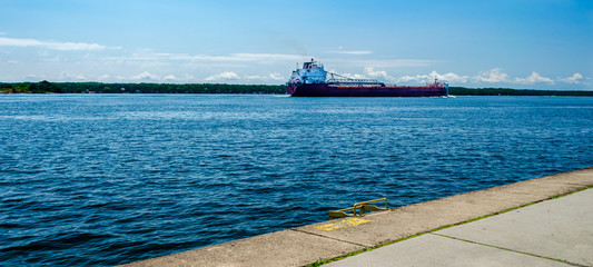 Freight ship sailing along the St. Lawrence River coastline