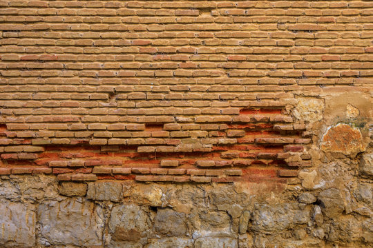 Wall of old, deteriorated bricks and stones, red, reddish