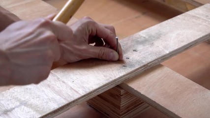 Worker fails to hammer nail into wooden board