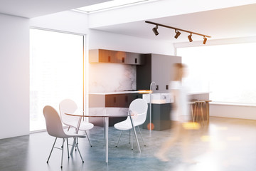 Woman in gray loft kitchen and dining room corner