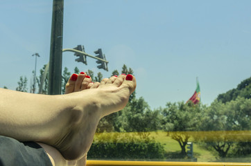 female legs against the backdrop of a tourist bus window