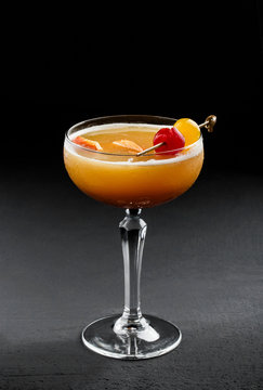 Fresh Fruit Tropic Cocktail With Peach, Orange In Tall Glass Over Dark Background. Summer Drinks And Alcoholic Cocktails.