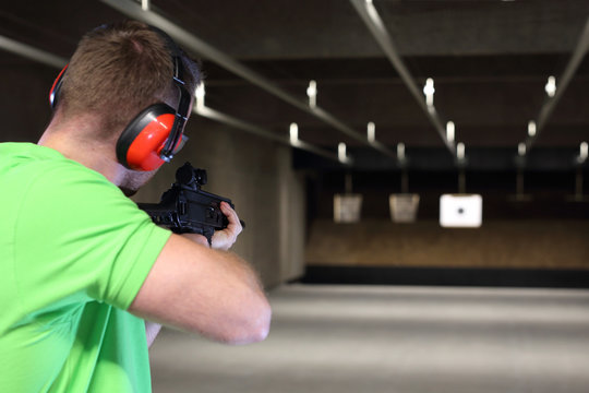 Strzelectwo. Przystojny mężczyzna trenuje strzelanie na strzelnicy sportowej.