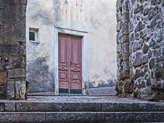 Altes Gebäude mit roter Tür in der Altstadt der Stadt Rab auf der Insel Rab, Kroatien