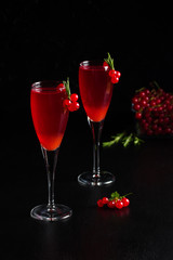 Two glasses redcurrant wine drink juice decorated with rosemary berries