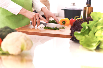 Close Up of human hands cooking vegetable salad in kitchen on the glass table with reflection. Healthy meal, and vegetarian food concept