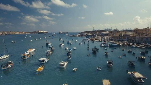 Aerial shot flying sideways over moored boats in Marsaxlokk