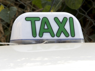 Close up of an taxi sign and its reflection