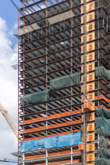 Naklejka premium Detail of a Skyscraper Under Construction in an Urban Downtown