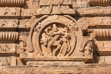 Ancient indian people with cow on temple wall, India. Example of Indian architecture in Pattadakal, UNESCO World Heritage site with stone carvings of 7th century