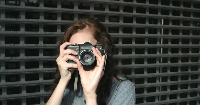 Hobby Female Photographer with vintage camera in the street