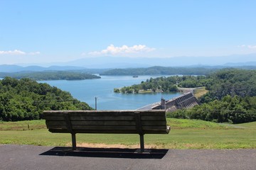 The empty park bench overlooking the dam and the lake. 