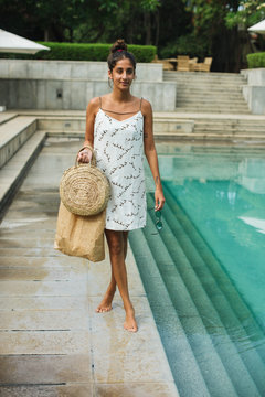 Woman in white dress near swimming pool