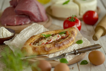 KHACHAPURI or hachapuri filled pie with egg and cheese. Open pie with egg and cheese. Flatbread with egg and cheese.