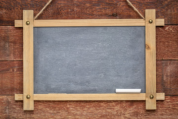 blank slate blackboard against rustic wood