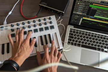 Musician is recording tunes on his computer music. first-person view