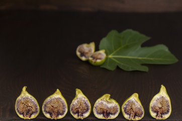 Feigenfrüchte in einer Reihe und feigenblatt im Hintergrund