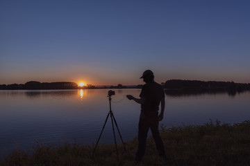 Silhouette von einem Fotografen beim untergang der Sonne am Rhein Iffezheim