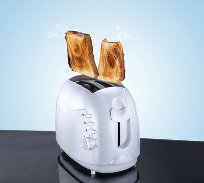 Toaster composite image and bread, flying and jumping bread cooked from an eletric toaster, blue background and reflective surface