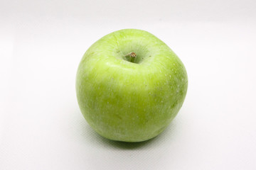 Green apple is lying  on a white background