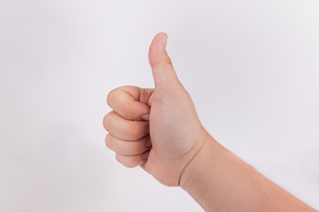Hand with a thumbs up hand gesture on solid white background 