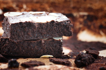 Dark chocolate brownies with almond topping, close up shot.