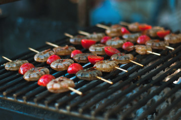  Marinated hot prawns with grilled tomatoes closeup. Seafood on the grill. protein health food. Select focus.