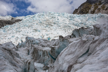 Helicopter flying over the summit of Franz Josef Glacier, with foreground ice in shadow; south...