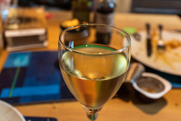 A Glass of White Wine on a Messy Table