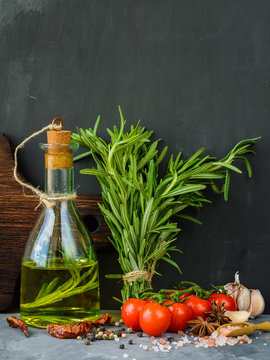 Rosemary oil. Selection of spices herbs. Ingredients for cooking. Food background on stone table.