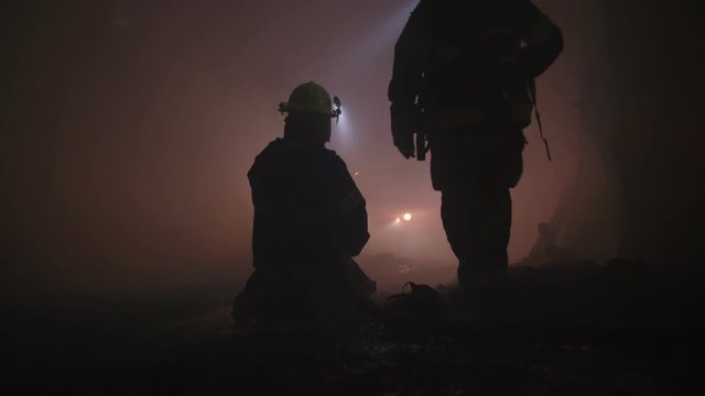 Firefighters during a rescue operation in a dark tunnel filled with smoke