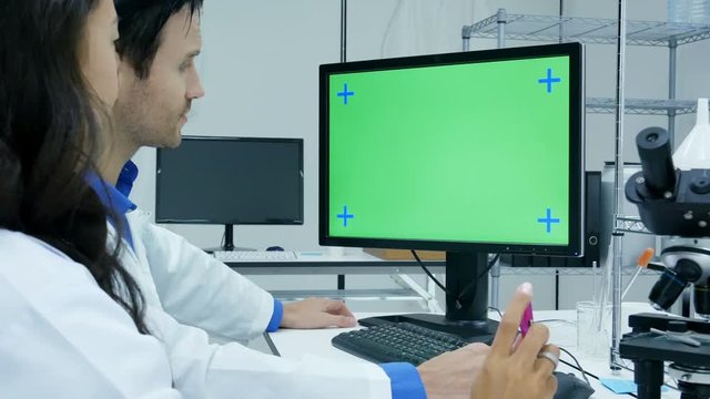Scientists or chemists using computer for work. Green screen marking on desktop. 4k resolution.