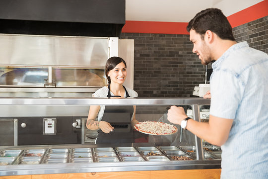 Customer Man Choosing Toppings From Counter With Women Chef Taking Order