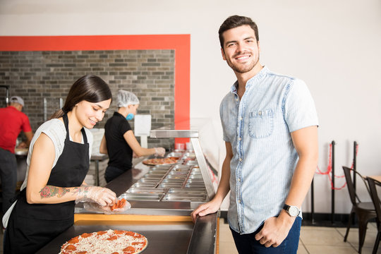 Handsome customer standing at pizza counter