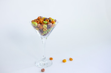 Colorful fruity loops cereal in a martini glass on a white background