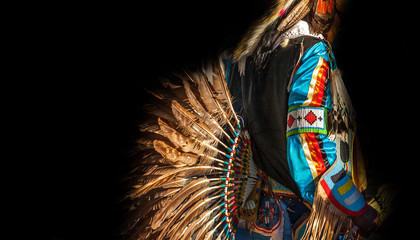 Native American Indian. Close up of colorful dressed native man isolated on black background.